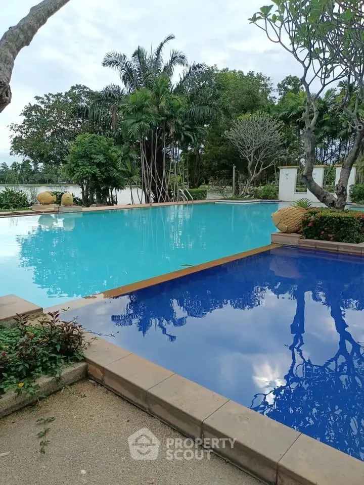 Luxurious outdoor pool area with lush greenery and serene ambiance.