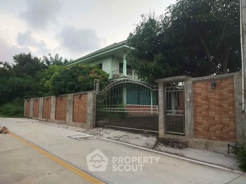 Charming suburban home with gated entrance and lush greenery