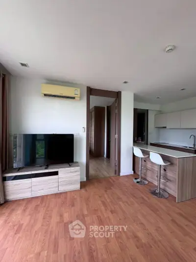 Modern living room with open kitchen and stylish wooden flooring