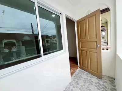 Charming balcony with open door and view of neighboring houses