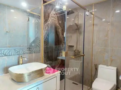 Luxurious modern bathroom with elegant gold accents and spacious shower area.