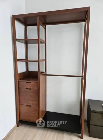 Spacious wooden wardrobe with shelves and drawers, perfect for organizing clothes in a modern bedroom.