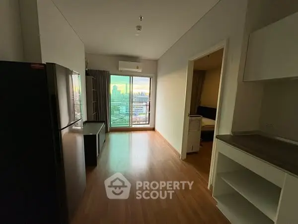 Modern apartment with open layout and city view, featuring sleek kitchen and spacious living area.