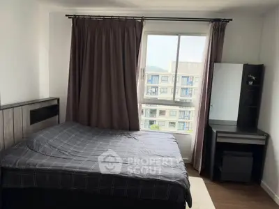 Cozy bedroom with large window and modern furniture in urban apartment