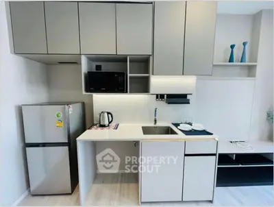 Modern kitchen with sleek cabinetry and stainless steel appliances in a compact layout.