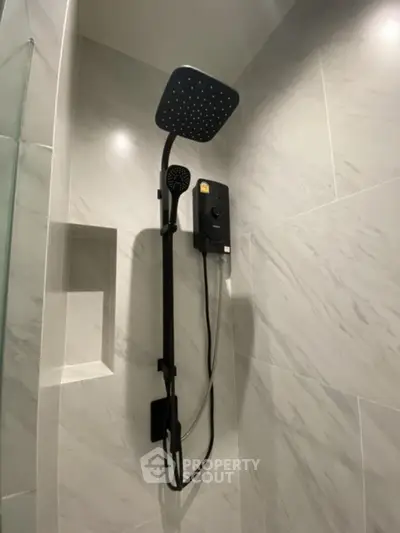 Modern bathroom shower with sleek black fixtures and marble tiles
