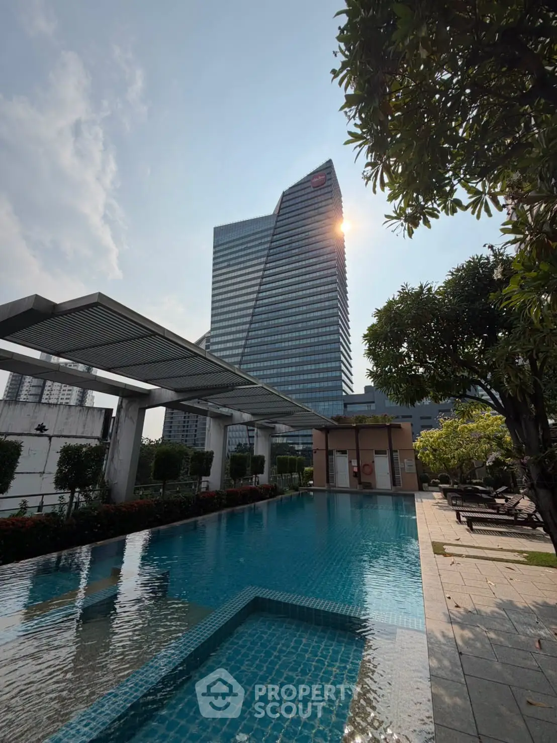 Luxurious high-rise building with stunning pool and lush greenery, perfect for urban living.