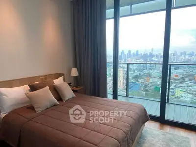Luxurious bedroom with stunning city view and spacious balcony in modern high-rise apartment.
