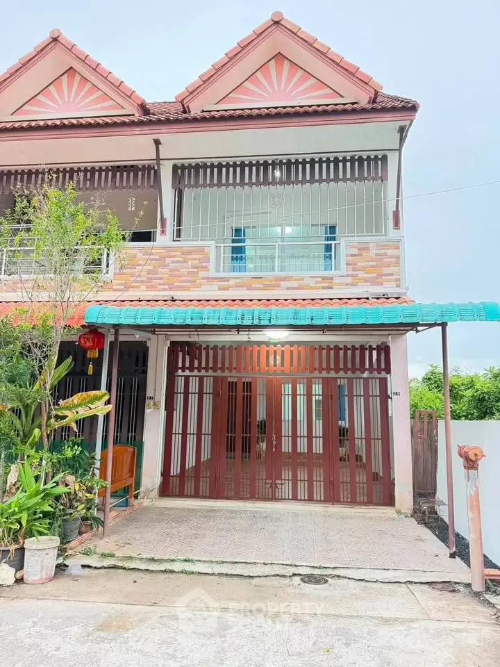 Charming two-story townhouse with unique architectural design and spacious front patio.