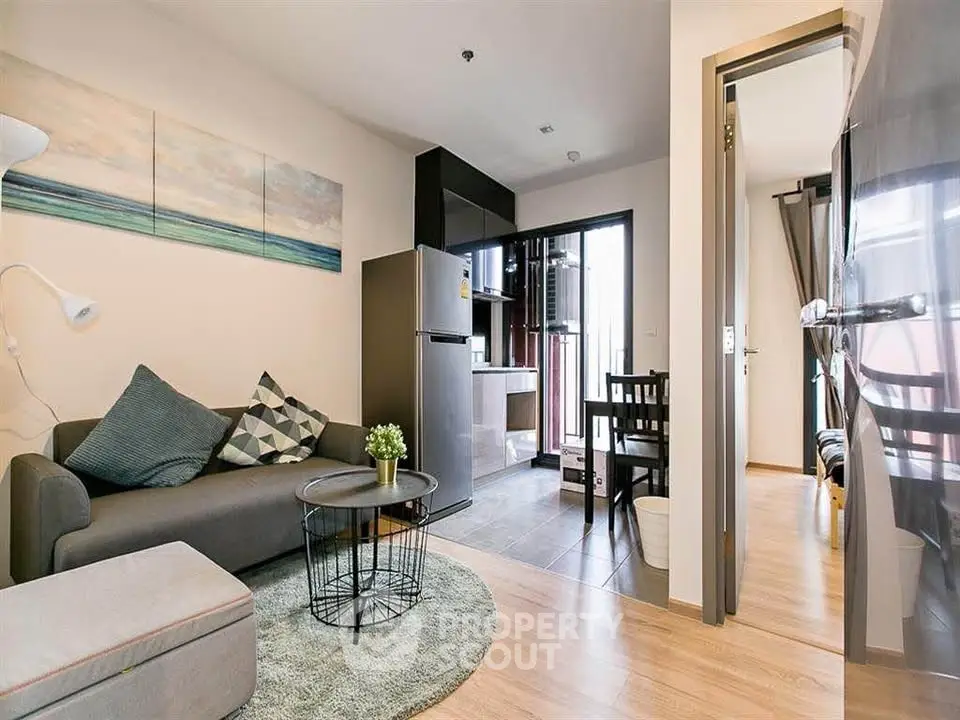 Modern living room with open kitchen and stylish decor in a cozy apartment.