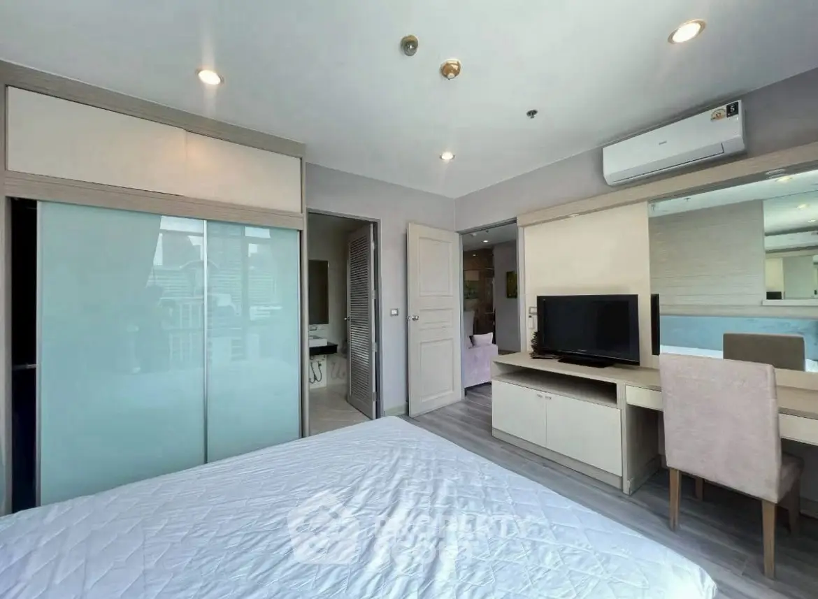 Modern bedroom with sleek design, featuring built-in wardrobe and cozy workspace.