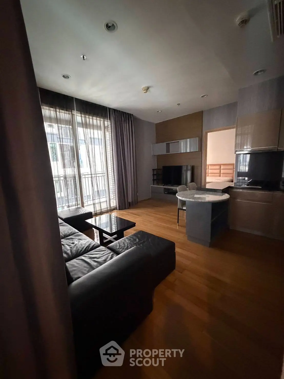 Modern living room with sleek furniture and large windows in a stylish apartment.