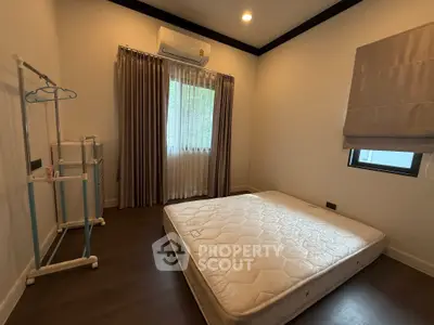 Minimalist bedroom with mattress and natural light from window