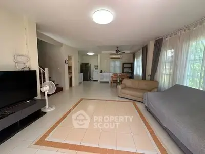 Spacious living room with modern furniture and natural light, perfect for family gatherings.
