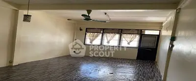 Spacious empty room with large windows and ceiling fan, ideal for customization.