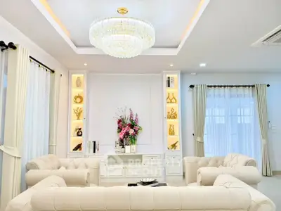 Luxurious living room with elegant chandelier and plush sofas in a bright, modern home.