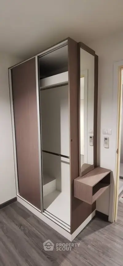 Modern built-in wardrobe with sliding doors and mirror in stylish apartment