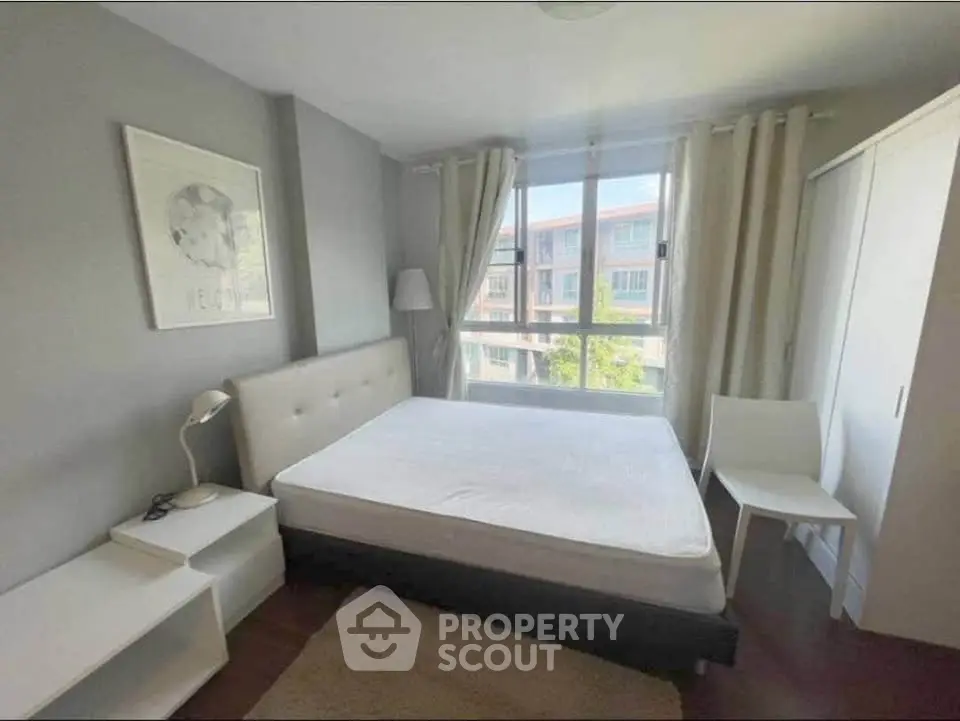 Bright and cozy bedroom with large window and modern furnishings