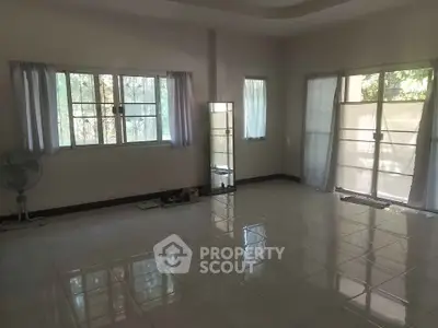 Spacious empty room with large windows and tiled flooring, perfect for customization.