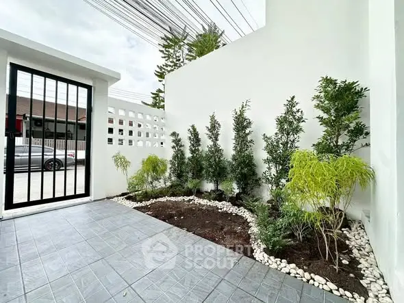 Charming garden entrance with modern design and lush greenery.