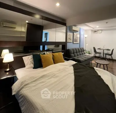 Modern bedroom with stylish decor and cozy seating area, perfect for urban living.