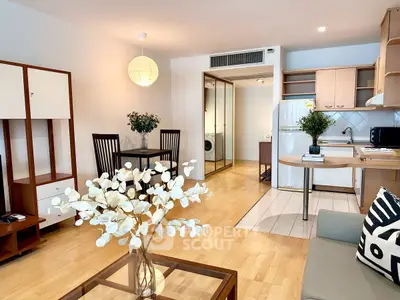 Modern open-plan living room with dining area and kitchen, featuring stylish decor and natural light.