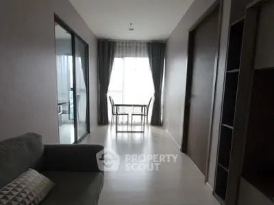 Modern apartment interior with cozy living area and dining space near large window.