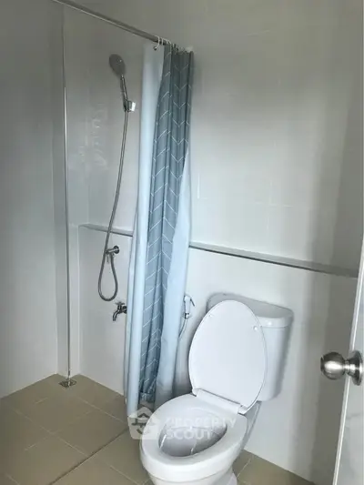 Modern bathroom with shower and toilet in minimalist design.