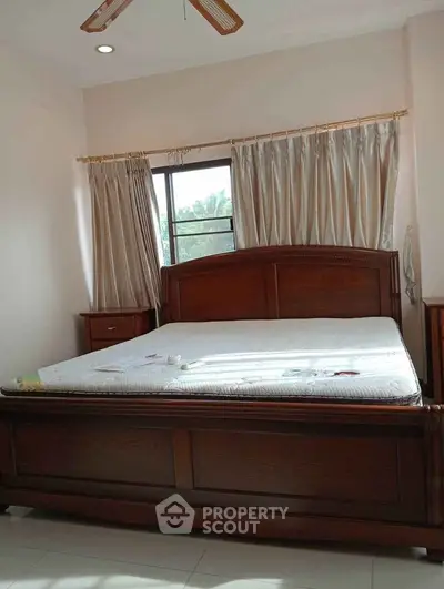 Spacious bedroom with elegant wooden bed and natural light