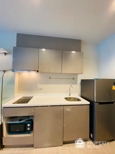 Modern kitchen with sleek cabinets and stainless steel appliances in a contemporary apartment.