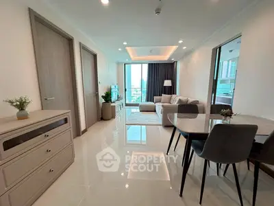 Modern living room with sleek furniture and large windows offering city views.