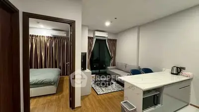 Modern apartment interior with open living room and kitchen, featuring sleek furniture and wooden flooring.
