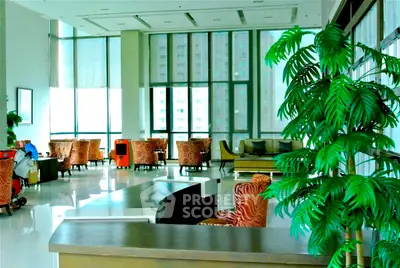 Spacious and elegant living area with modern furniture and large windows.