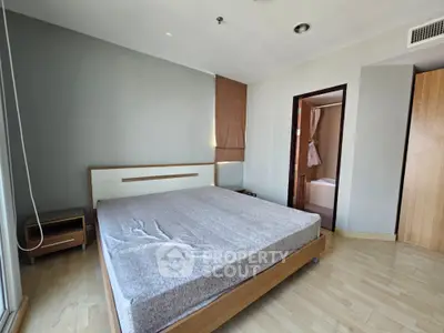 Spacious bedroom with modern design and ensuite bathroom in a stylish apartment.