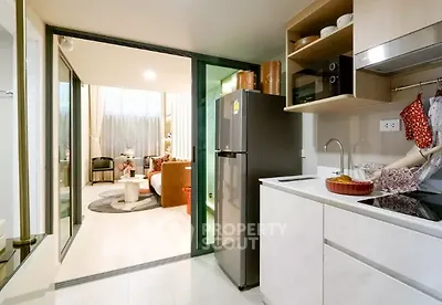 Modern open-layout kitchen with sleek appliances and view into cozy living area.