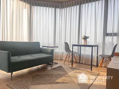 Sun-drenched modern living room with elegant sheer curtains, chic furniture, and a cozy ambiance perfect for relaxation or entertaining guests.