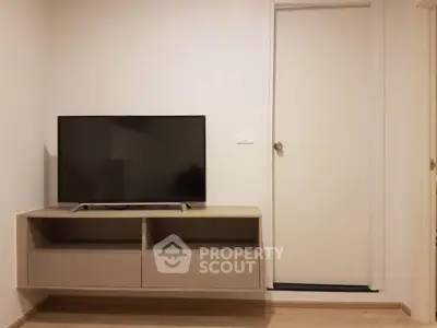 Modern living room with sleek TV stand and wall-mounted flat-screen TV.