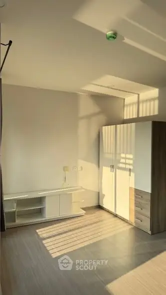 Bright and spacious bedroom with modern wardrobe and ample natural light.