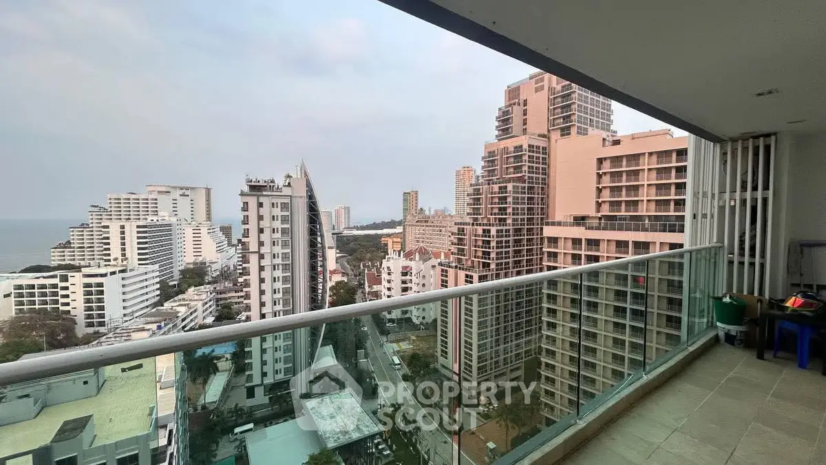 Stunning high-rise balcony view overlooking cityscape and ocean horizon.