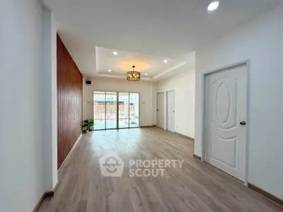 Spacious modern living room with elegant lighting and large sliding doors opening to a patio.