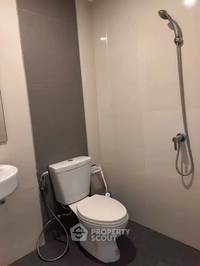 Modern bathroom with sleek shower and toilet in minimalist design.