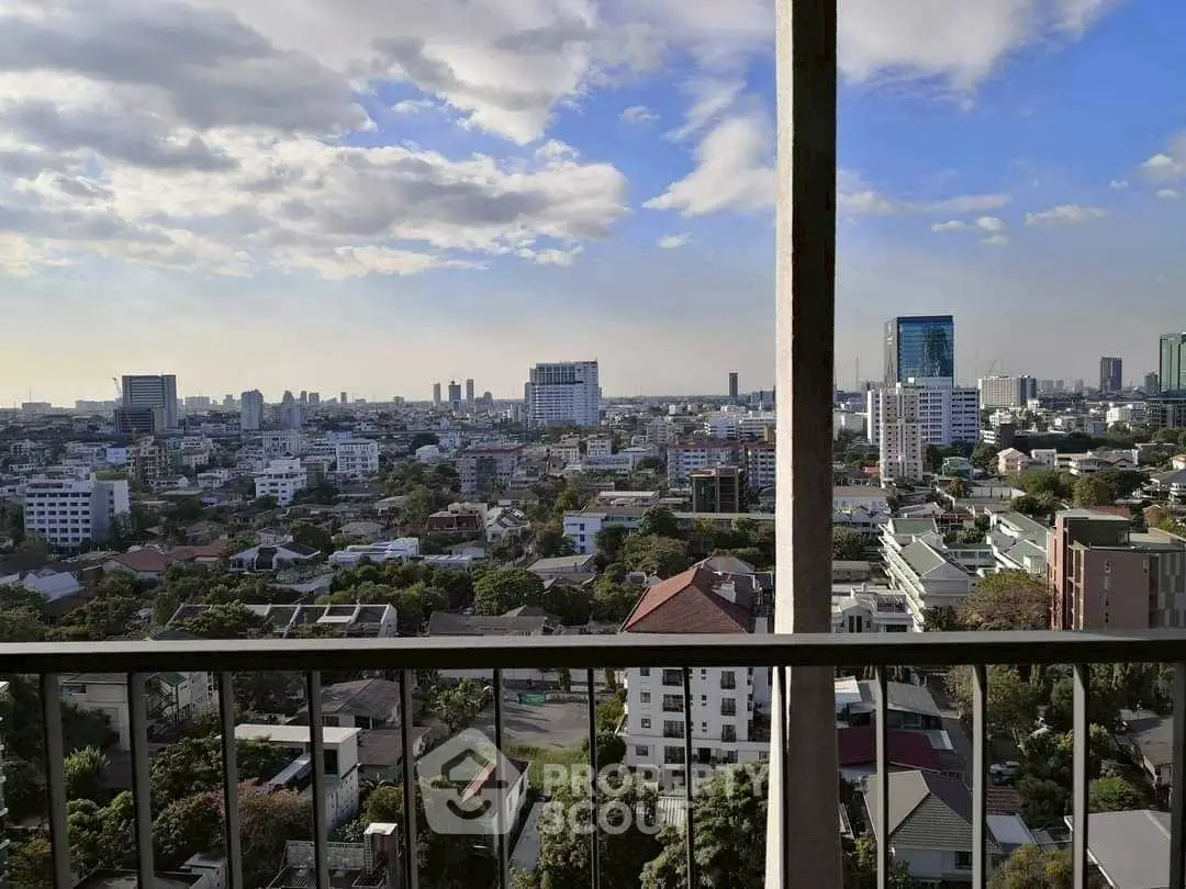 Stunning cityscape view from a high-rise balcony showcasing urban skyline and blue skies.