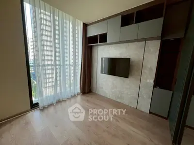 Modern living room with floor-to-ceiling windows and built-in TV unit in a high-rise apartment.