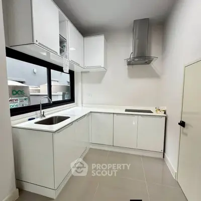 Modern white kitchen with sleek cabinets and built-in appliances