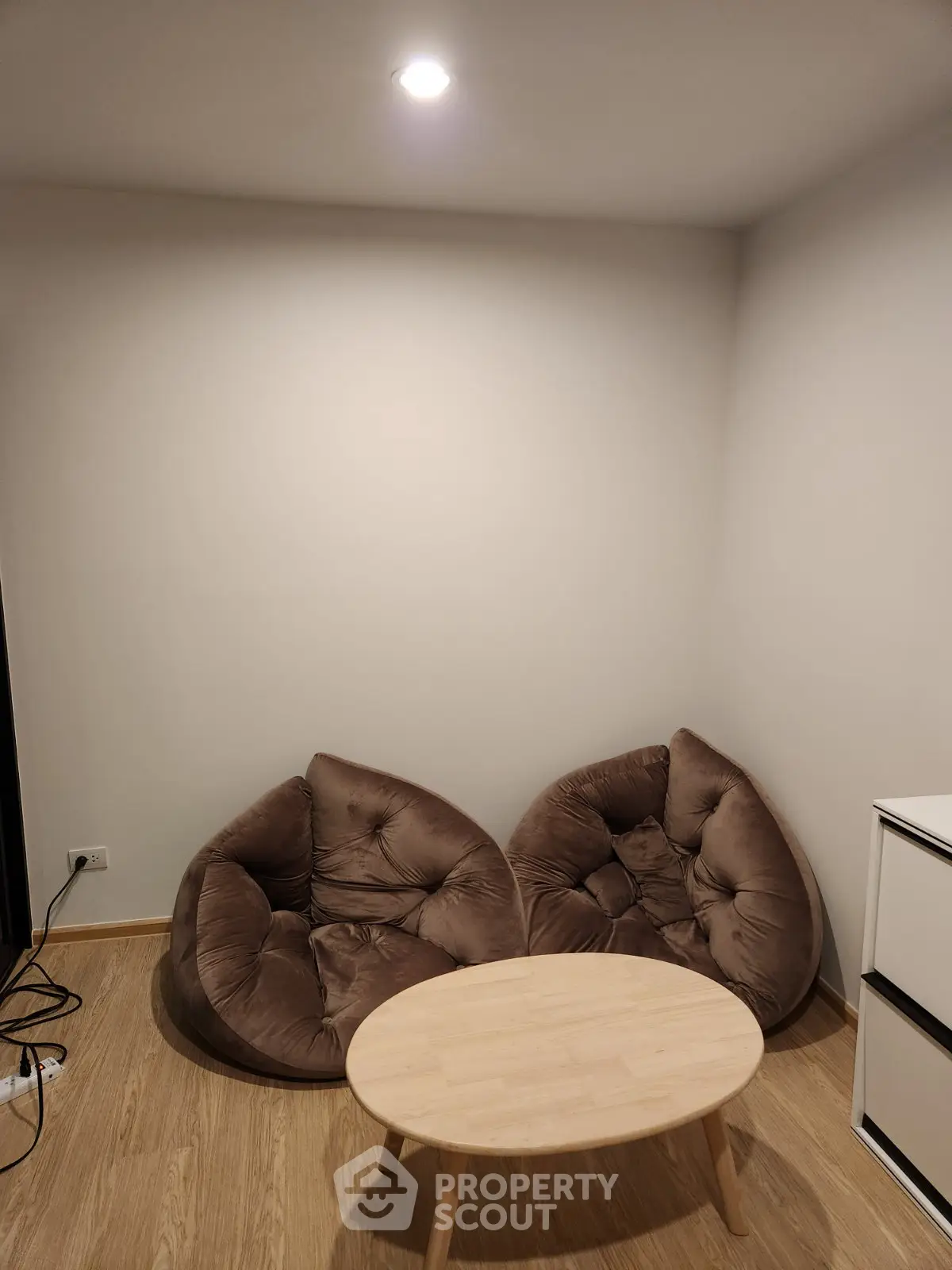 Cozy minimalist living room with bean bag chairs and wooden coffee table.