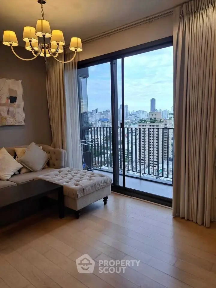 Luxurious living room with elegant chandelier and stunning city view from balcony.