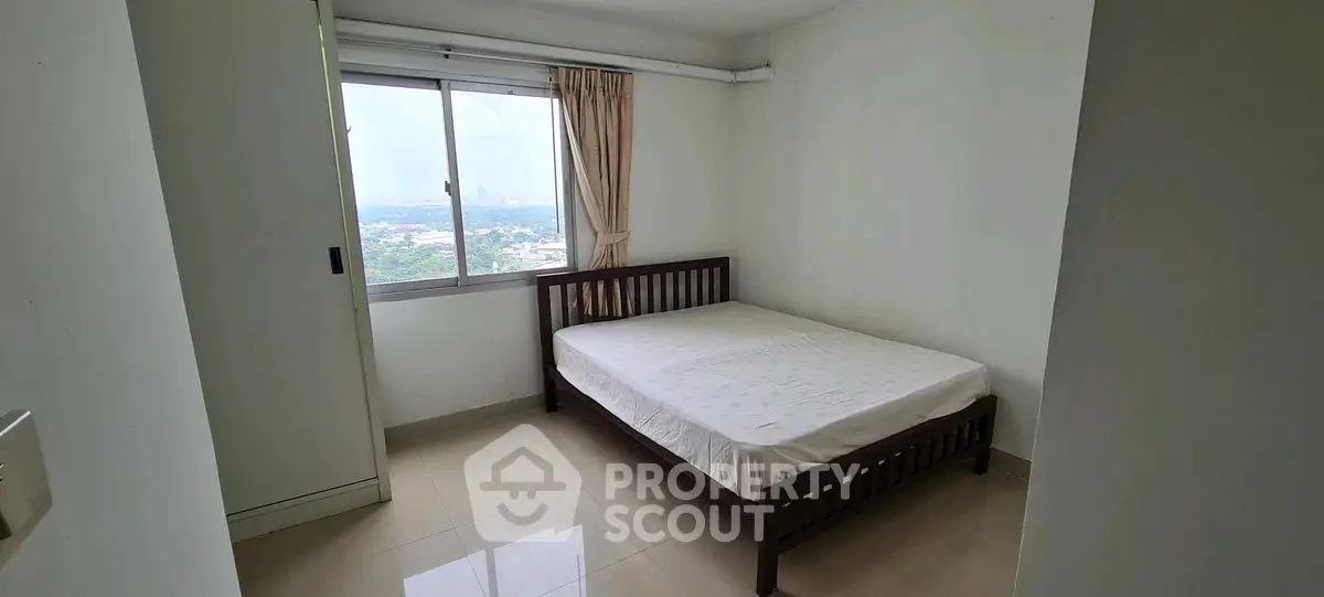 Cozy bedroom with large window offering scenic views, perfect for relaxation and comfort.