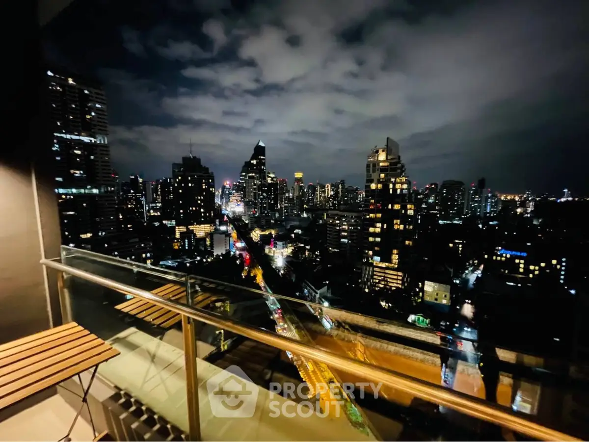 Stunning cityscape view from a modern balcony at night, showcasing vibrant urban lights.