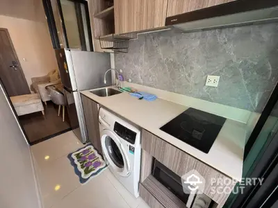 Modern compact kitchen with washing machine and electric stove in stylish apartment