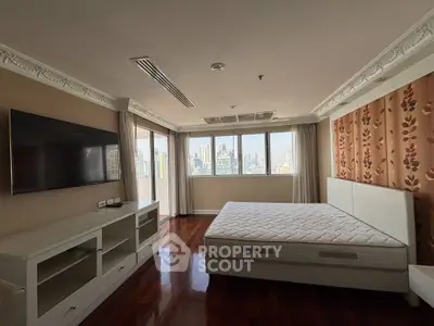 Spacious bedroom with city view, featuring large windows and modern furnishings.